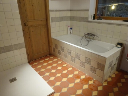 Carrelages en faience ton vieux blanc et frise grise en relief dans une salle de bain avec des Tomettes en terre cuite 16x16 rouge et losanges beiges