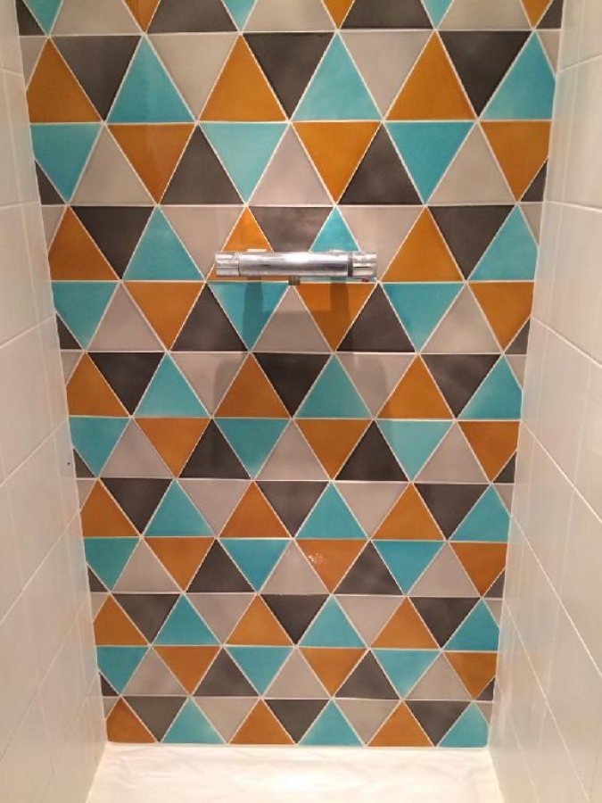Faience murale triangles de 15x15 dans une douche ton turquoise miel et gris